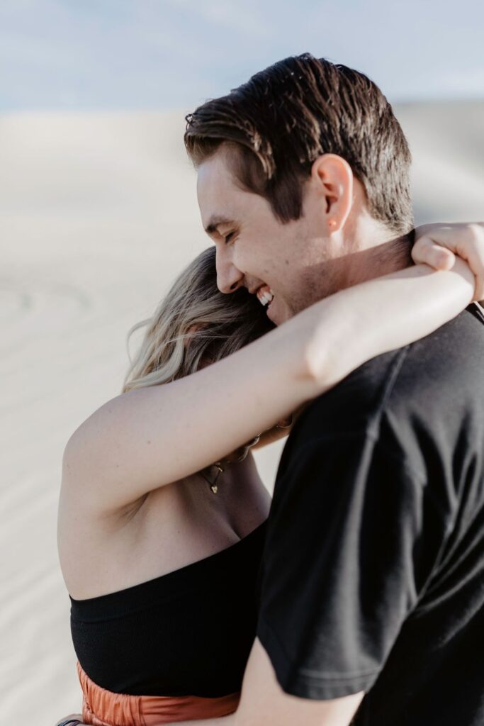 couples close up laughing together each other in sand dunes in nevada 