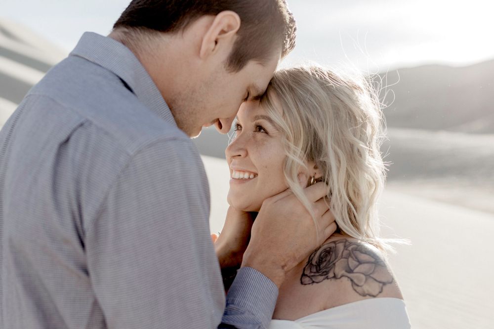 couple close-up looking at each other in nevada desert sand dunes during engagement session by katherine krakowski photography