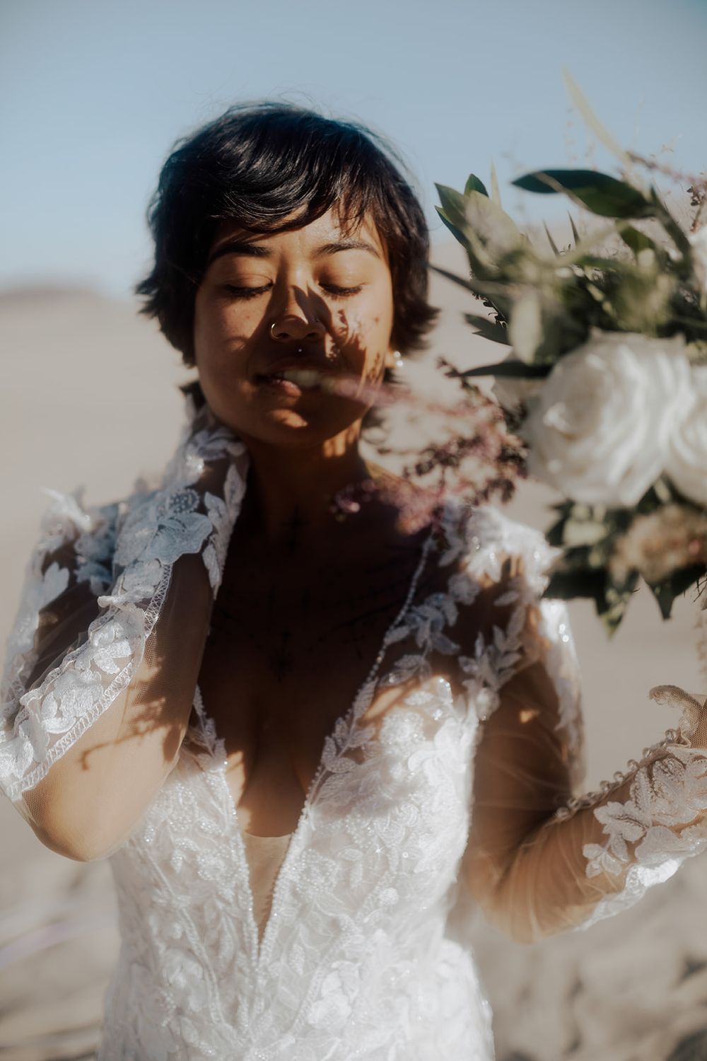 bride with bridal bouquet shadow on face in sand dunes desert nevada taken by katherine krakowski