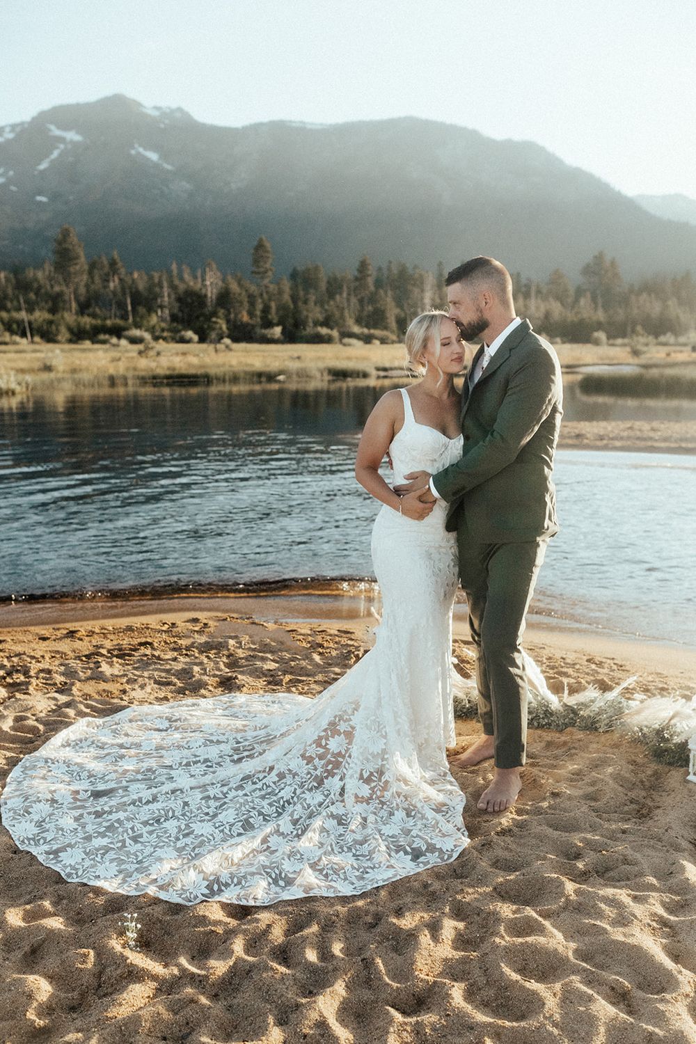 wedding couple holding each other on beach during bridal photos after elopement taken by katherine krakowski lake tahoe reno photographer