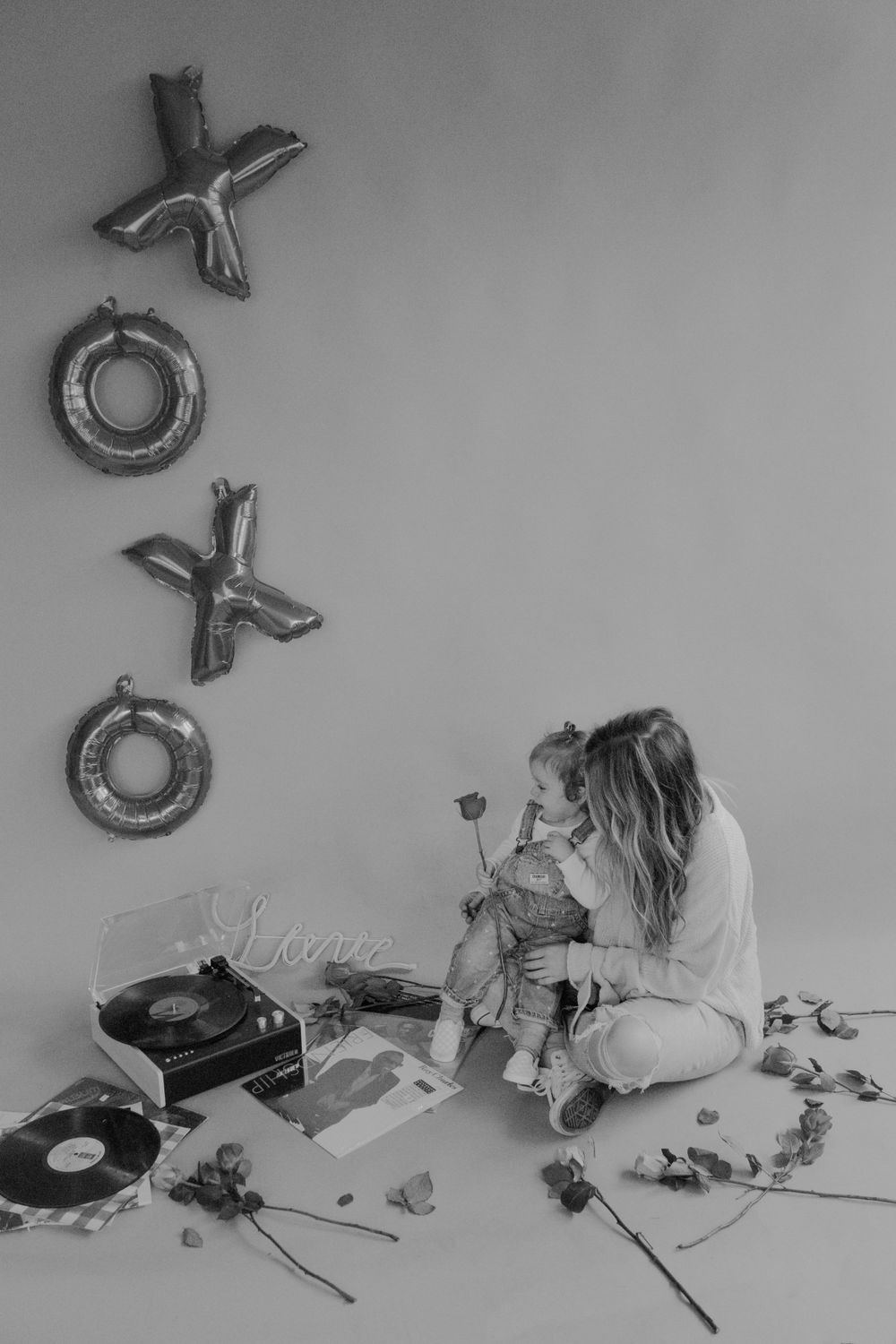 mother holding daughter playing with chocolate rose while listening to records in studio session by katherine krakowski lake tahoe reno photographer